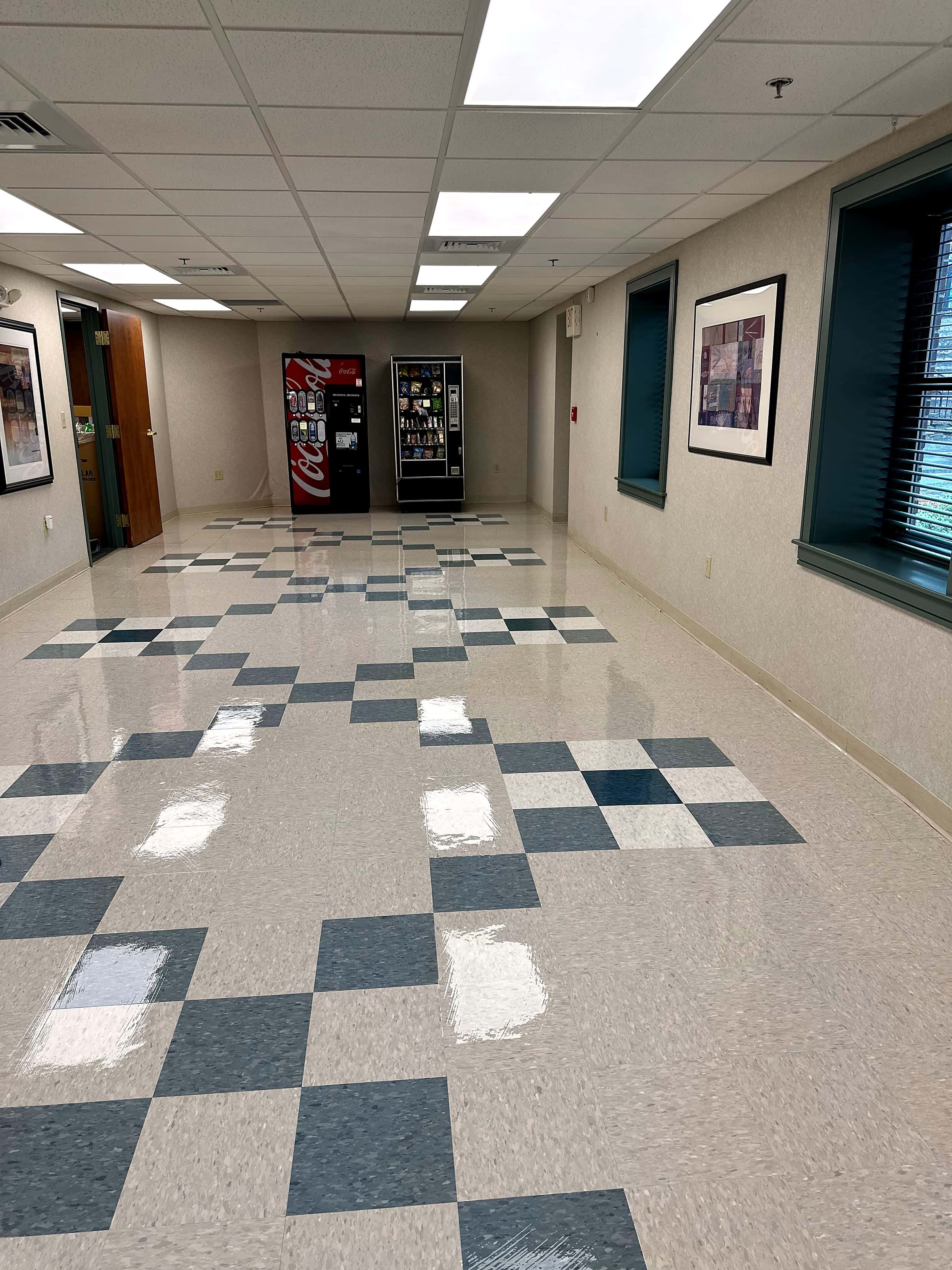 A lobby corridor with a burnished checkerboard tile floor.