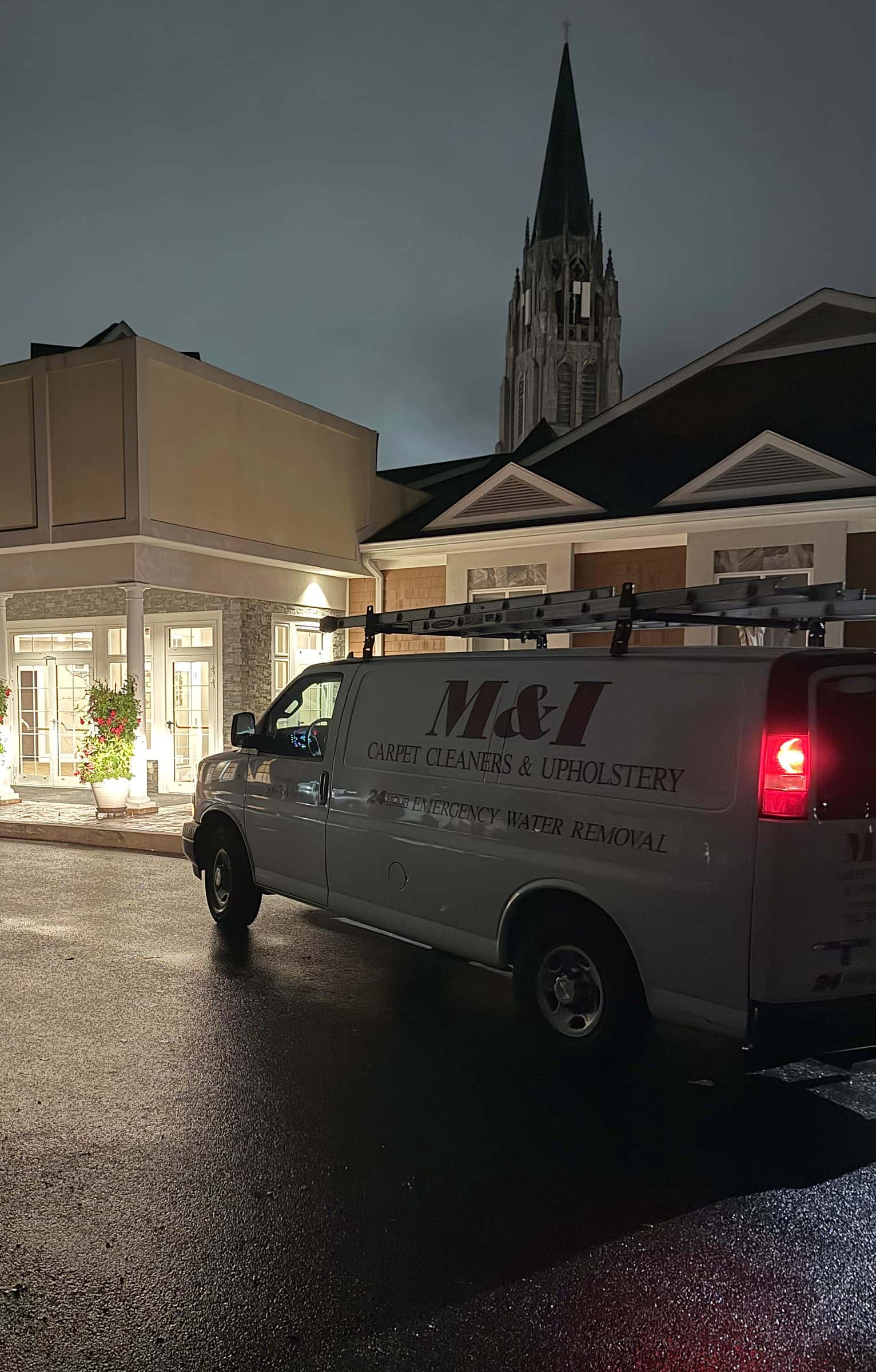 The MICS van parked on wet pavement at night outside a lit building entrance.