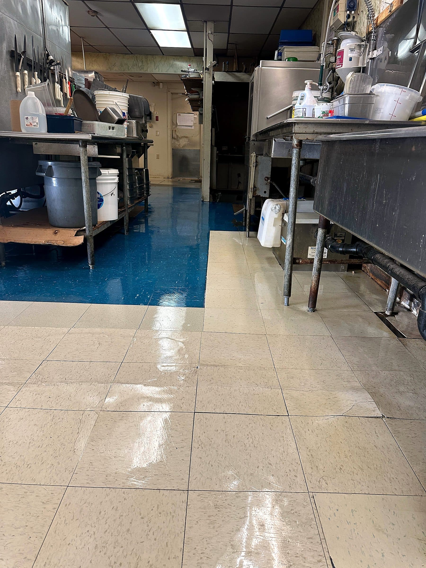 A commercial kitchen prep line with a polished blue and cream tile floor.